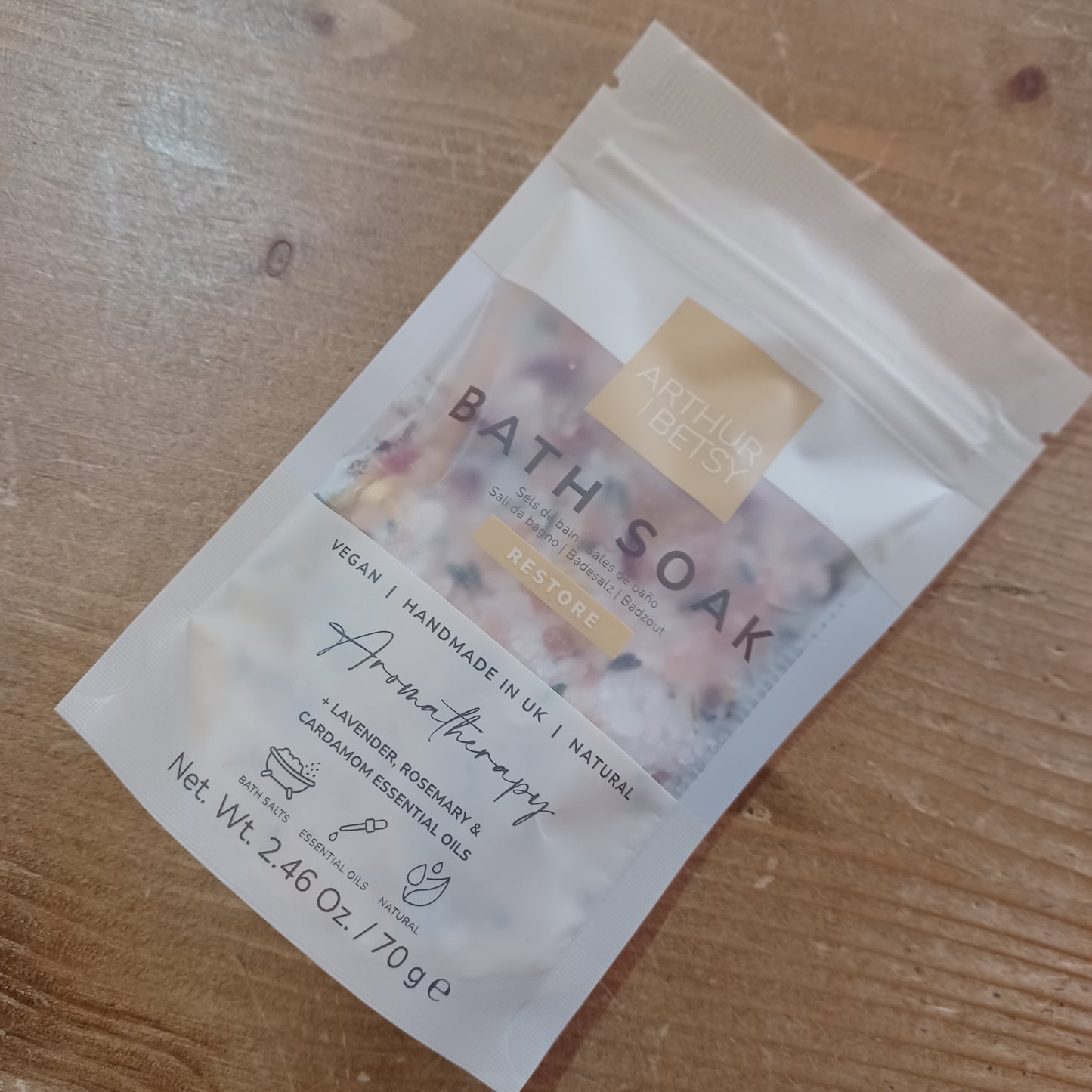 Bath soak packet on a wooden surface
