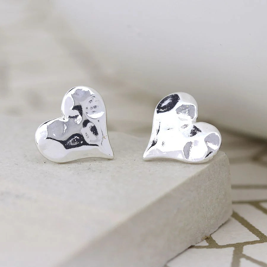 Silver heart-shaped earrings on a light surface
