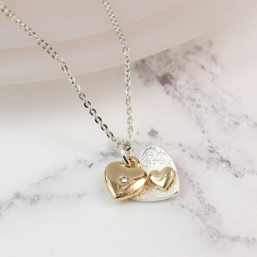 Gold heart-shaped pendant necklace on a marble surface
