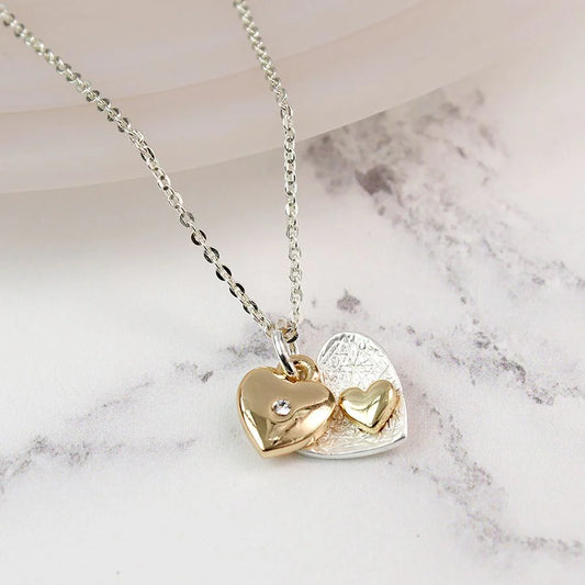 Gold heart-shaped pendant necklace on a marble surface