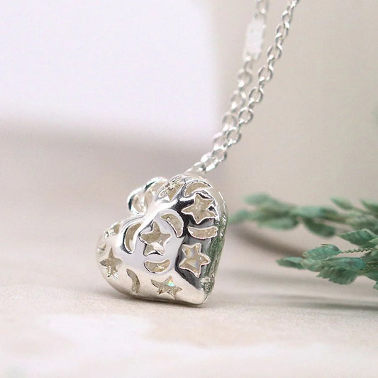 Silver heart-shaped pendant necklace with star designs on a light background