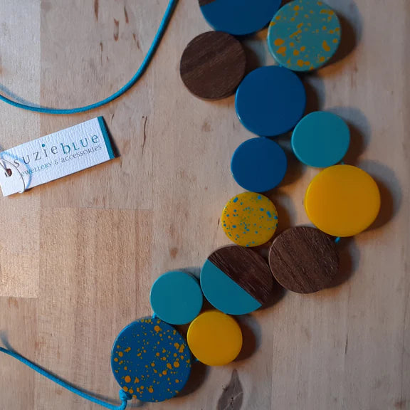 Colorful necklace with wooden and plastic components on a wooden surface