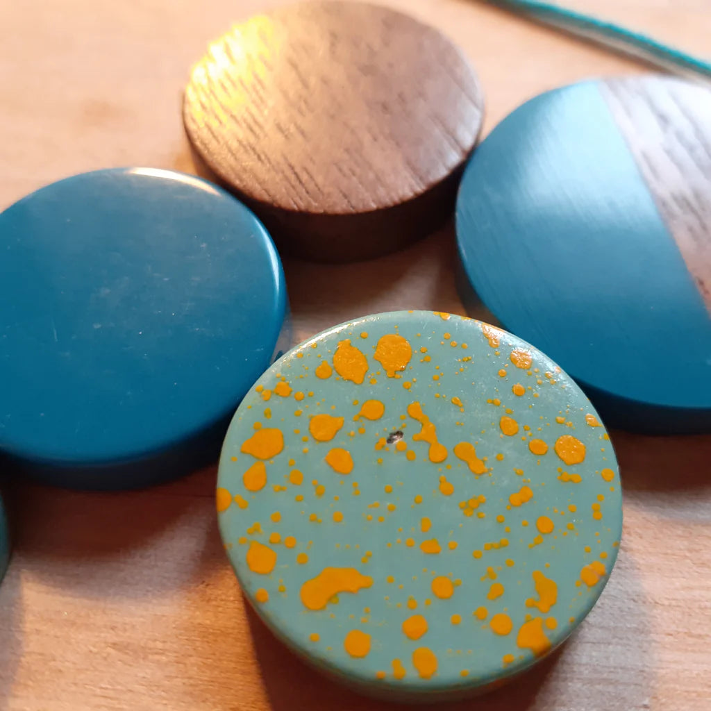 Close-up of wooden and ceramic items with blue and orange speckled design on a wooden surface.