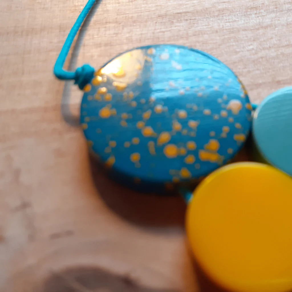 Colorful spotty container with a blue string on a wooden surface
