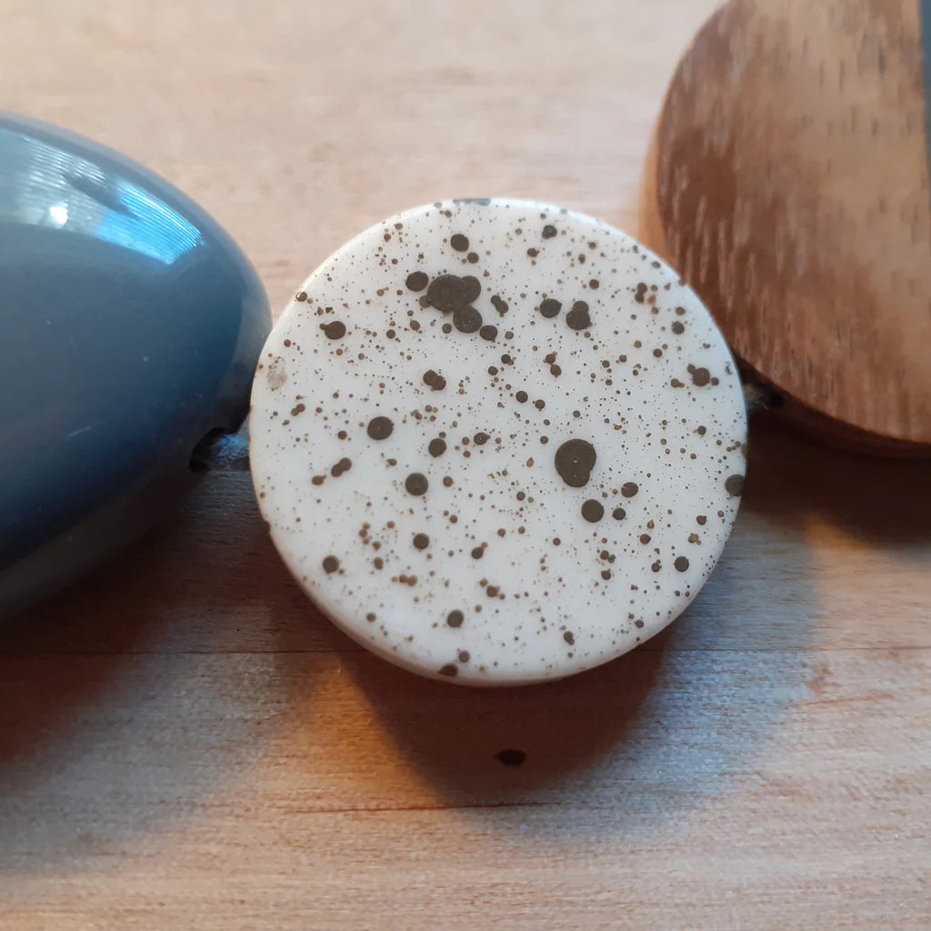 Speckled ceramic knob on a wooden surface