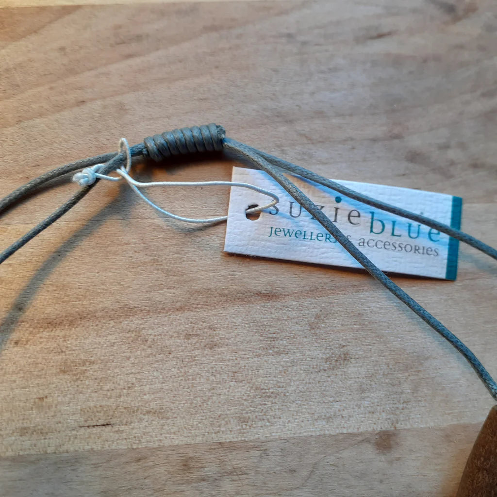 Gray cord with a visible brand tag on a wooden surface