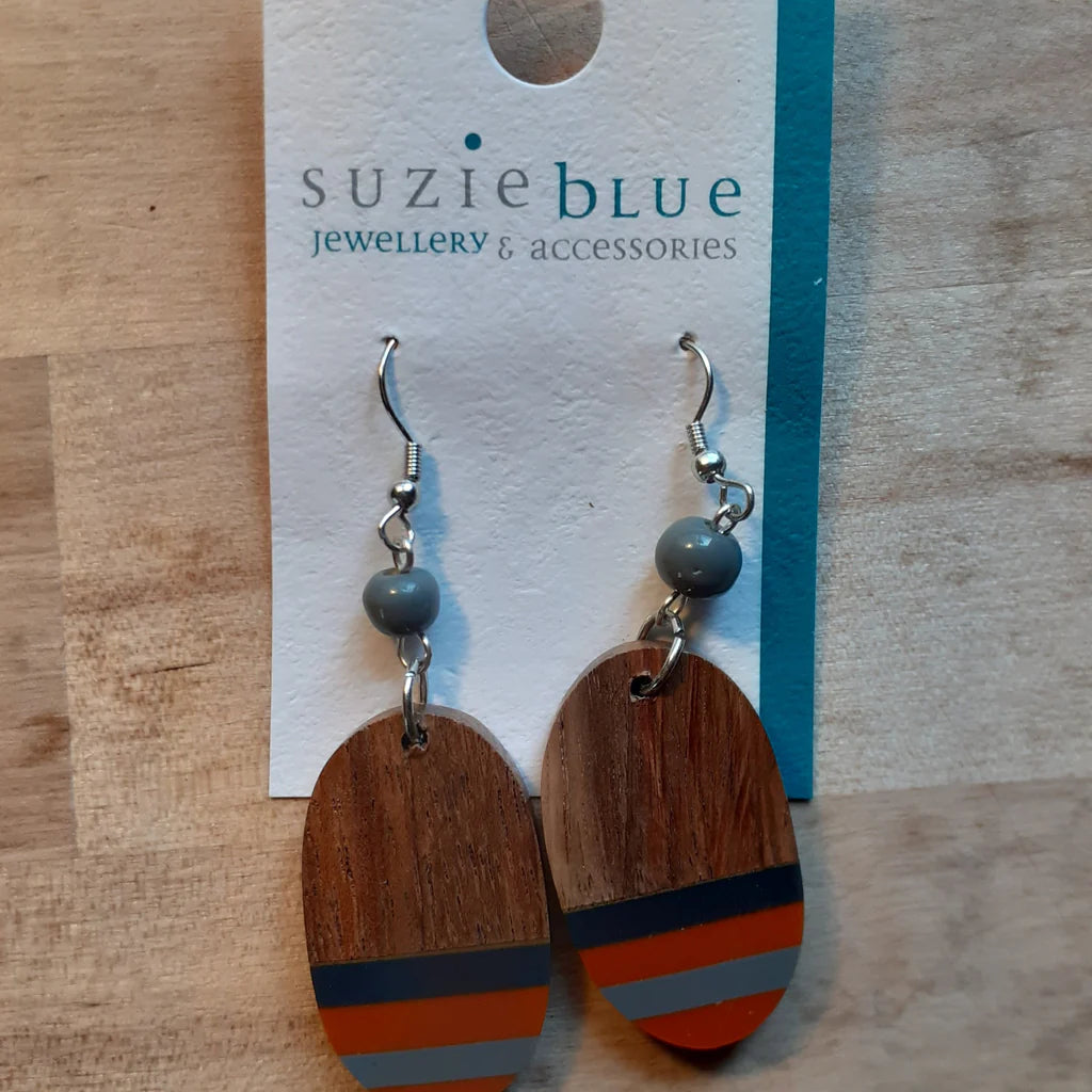 Wooden earrings with colorful stripes on a 'Suzie Blue' branded card.