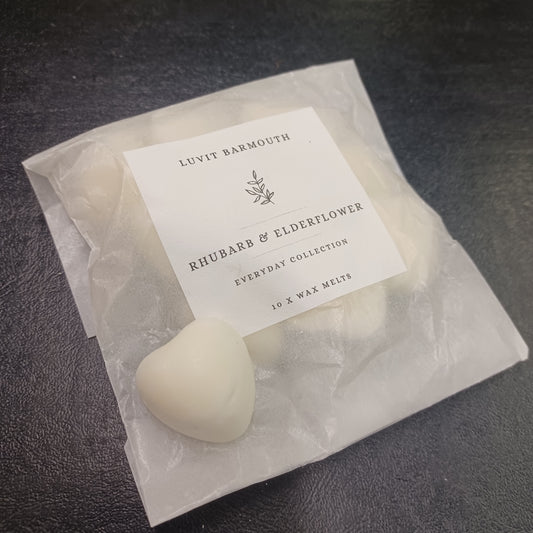 White wax melts in a clear bag with a label on a dark surface