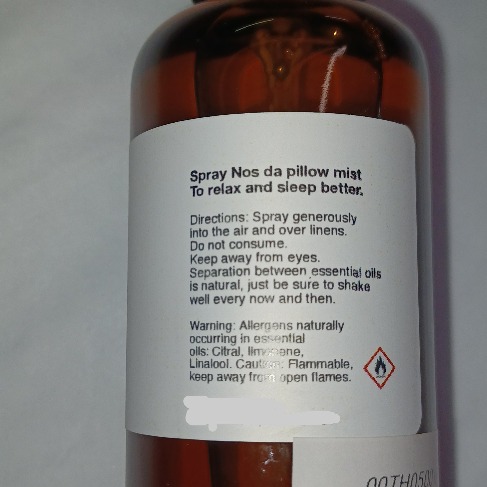 Bottle label with text and a warning symbol on a white background
