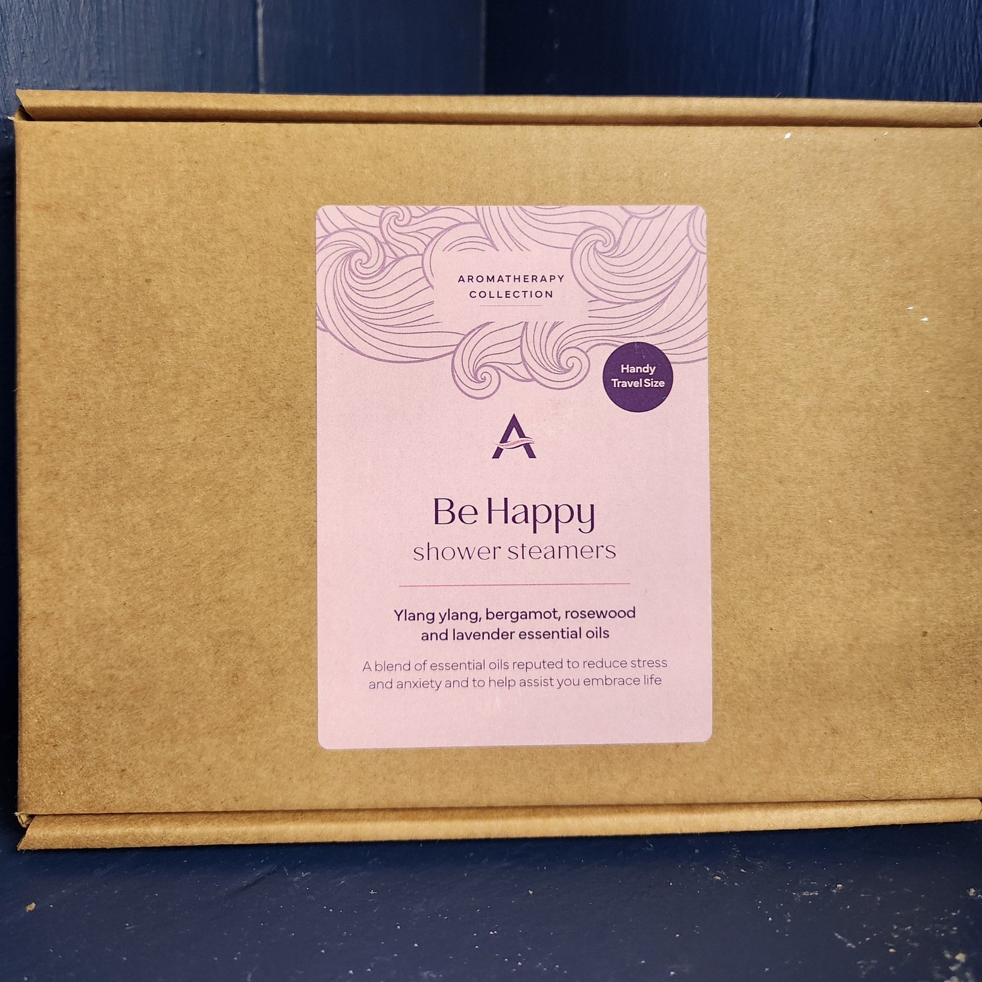 Brown cardboard box with a pink label on a blue wooden surface