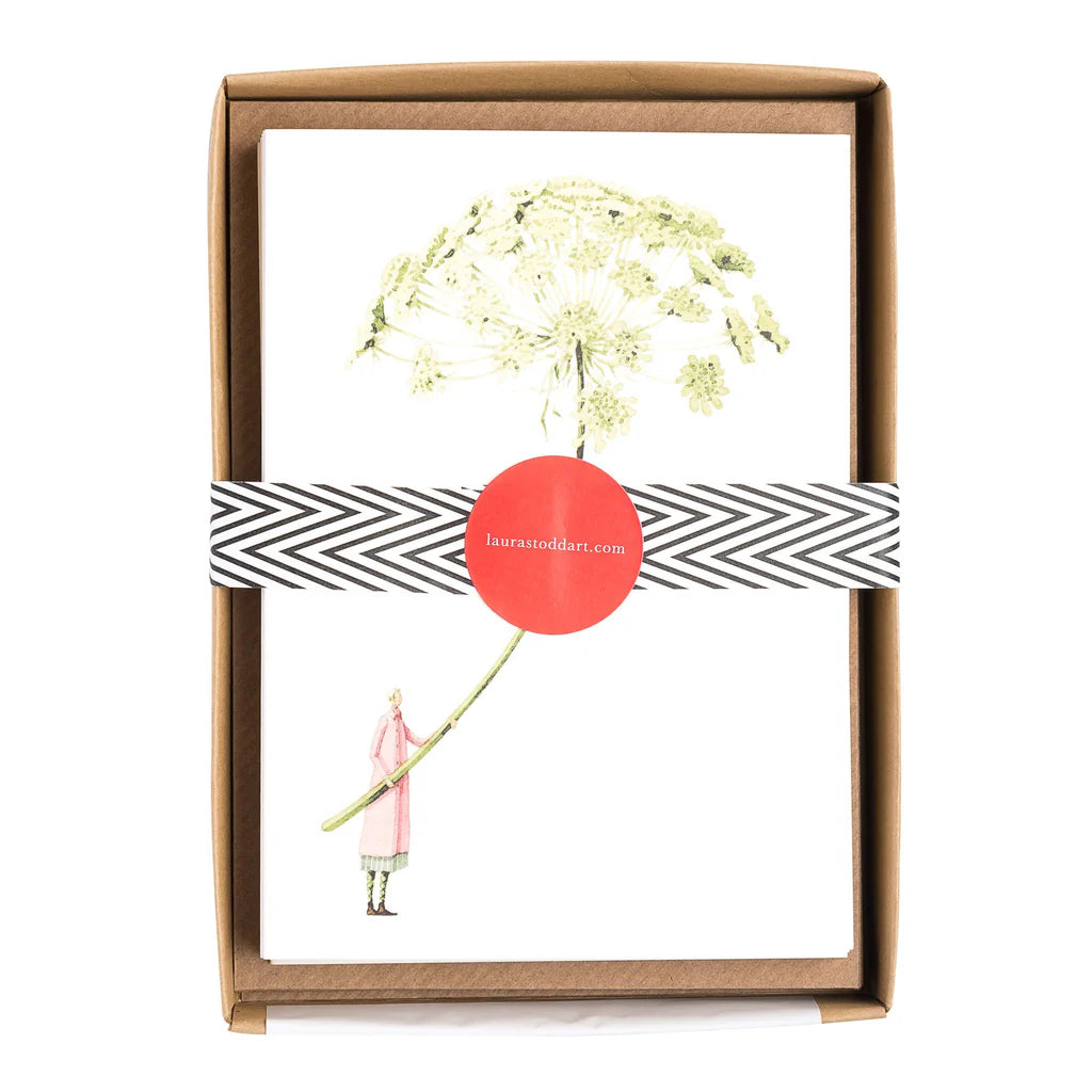 Framed artwork with a dandelion illustration and a person holding a stick, branded 'laurastoddard'.