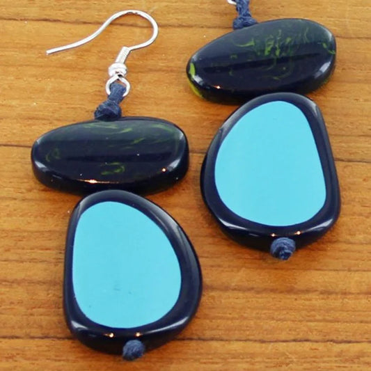 Blue and black stone earrings on a wooden surface