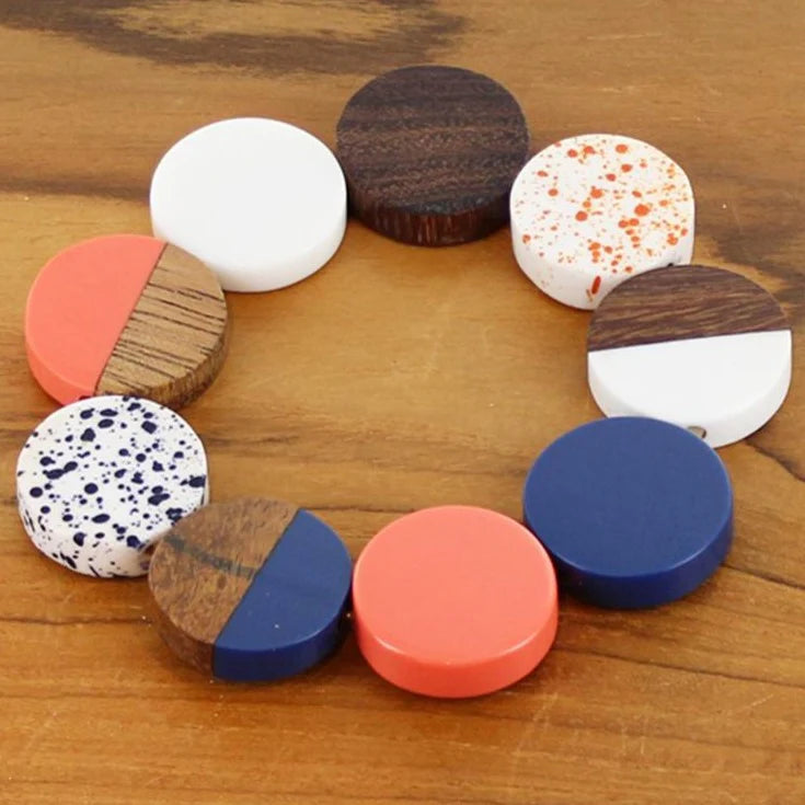 Colorful round objects with patterned designs arranged in a circle on a wooden surface