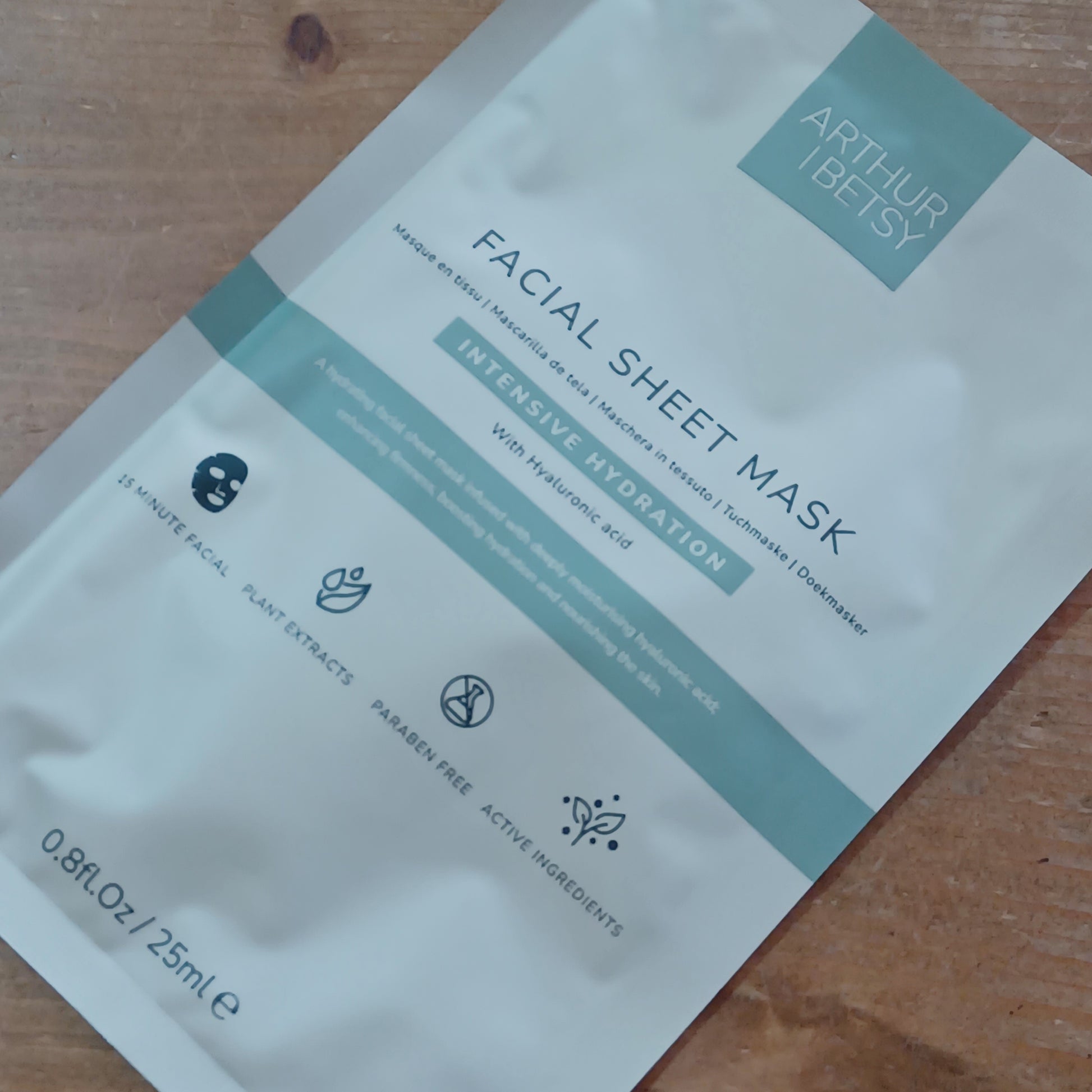 Facial sheet mask packaging on a wooden surface