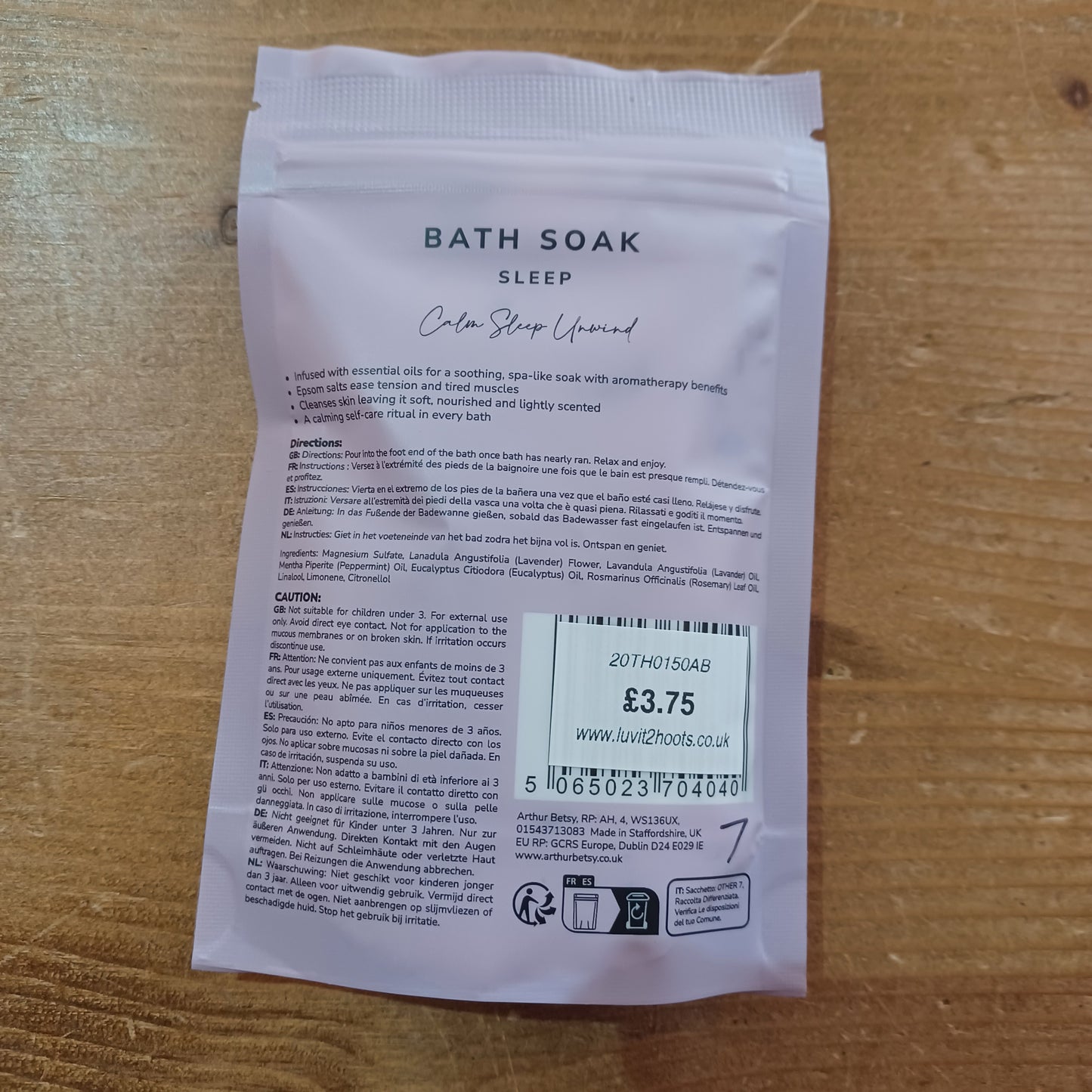 Bath soak packaging with text and a label on a wooden surface
