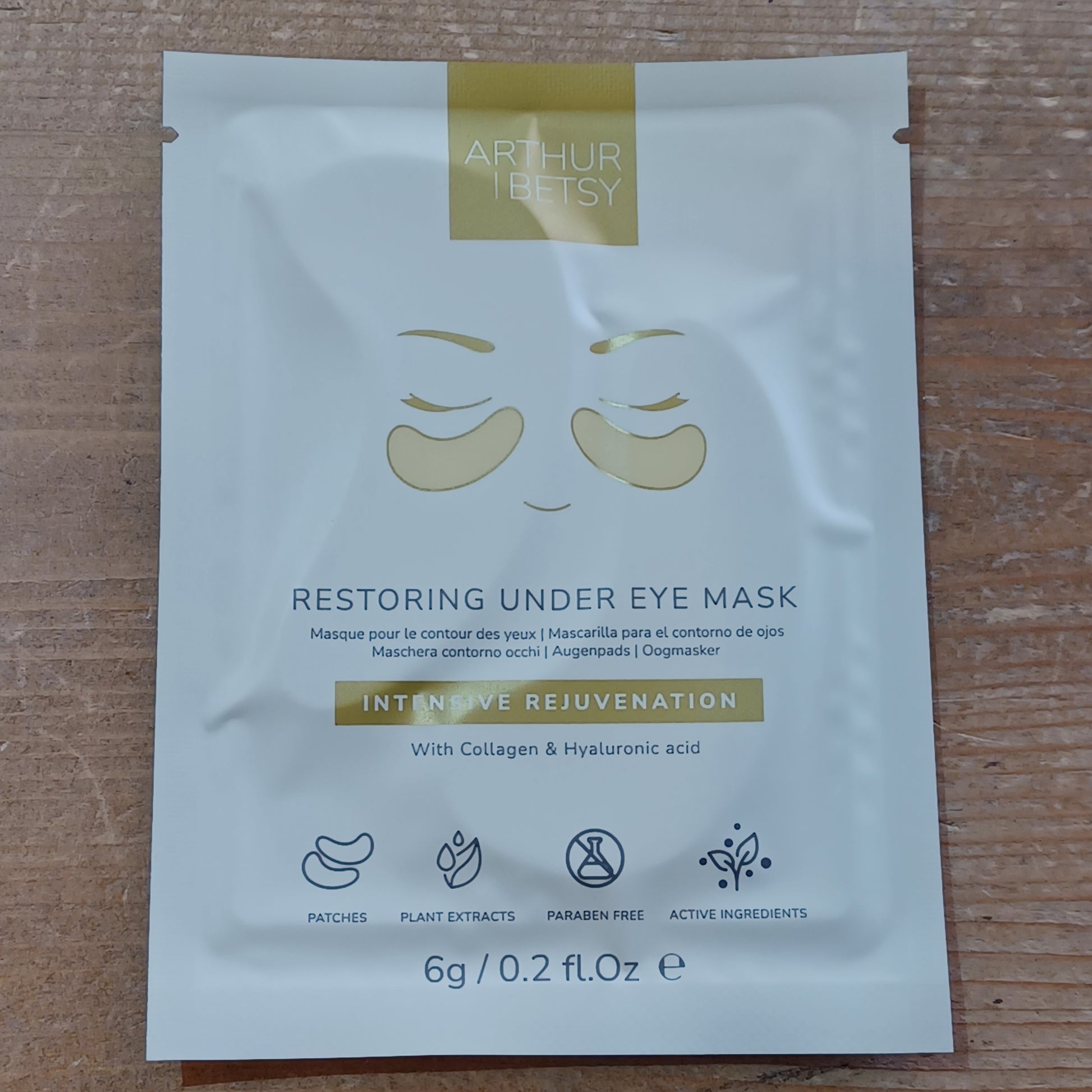 Under eye mask packaging with brand name on a wooden surface