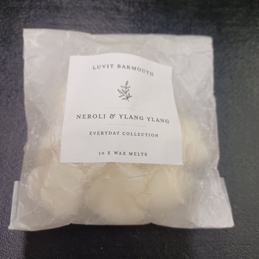 Packaged wax melts with a label on a dark surface