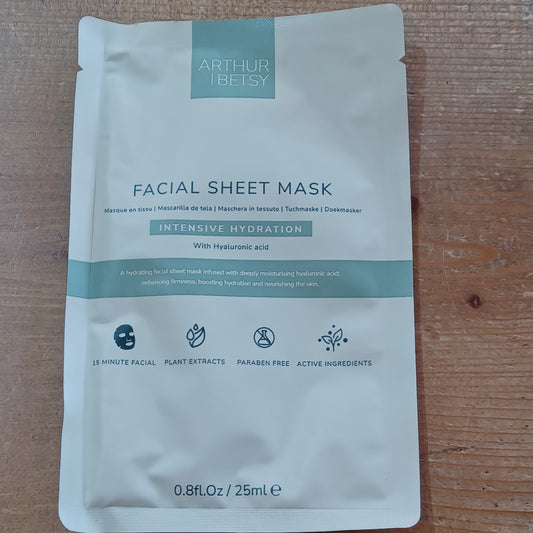 Facial sheet mask packaging on a wooden surface