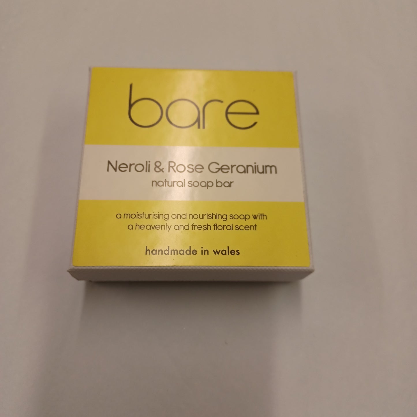 Yellow and beige soap packaging with 'bare' branding on a gray background