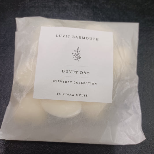 Packaged wax melts with a label on a dark surface