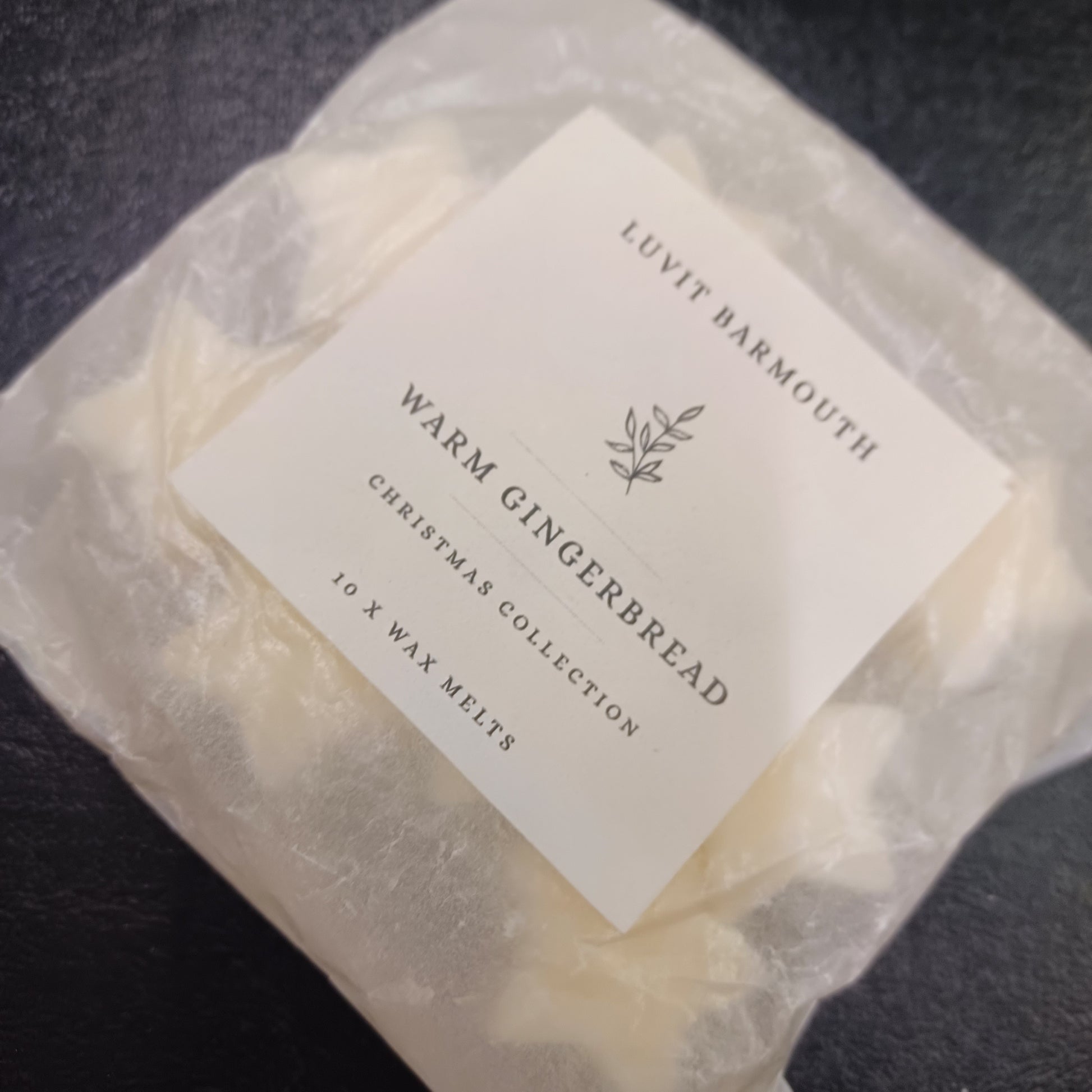 Packaged wax melts with a label on a dark surface