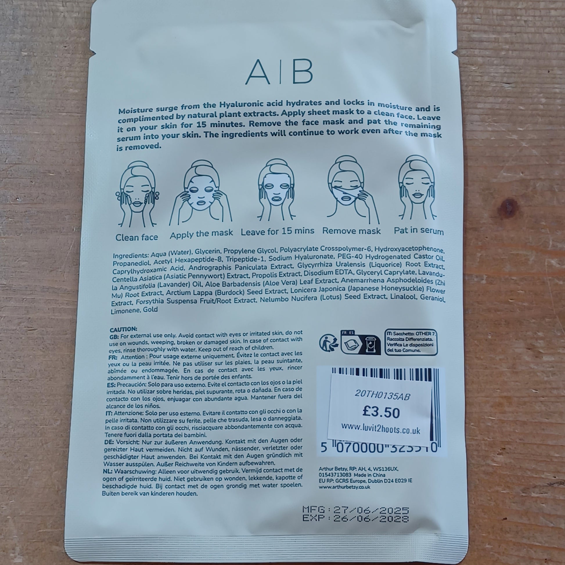 Back of a skincare mask packaging with text and barcodes on a wooden surface