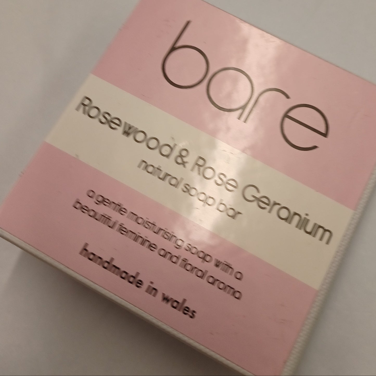 Pink soap bar packaging with 'bare' branding on a light gray background