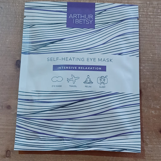 Self-heating eye mask packaging with wavy design on a wooden surface