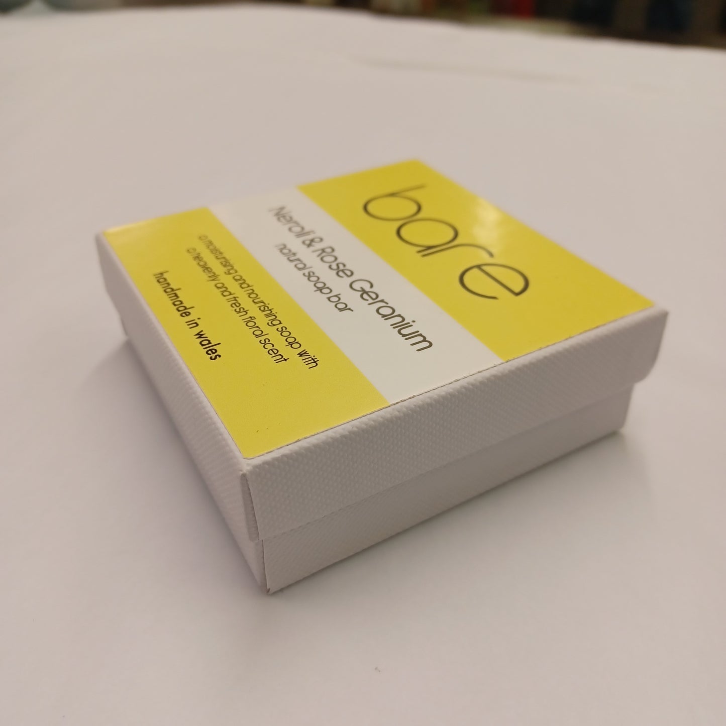 Box of 'bare' soap with yellow label on a white background
