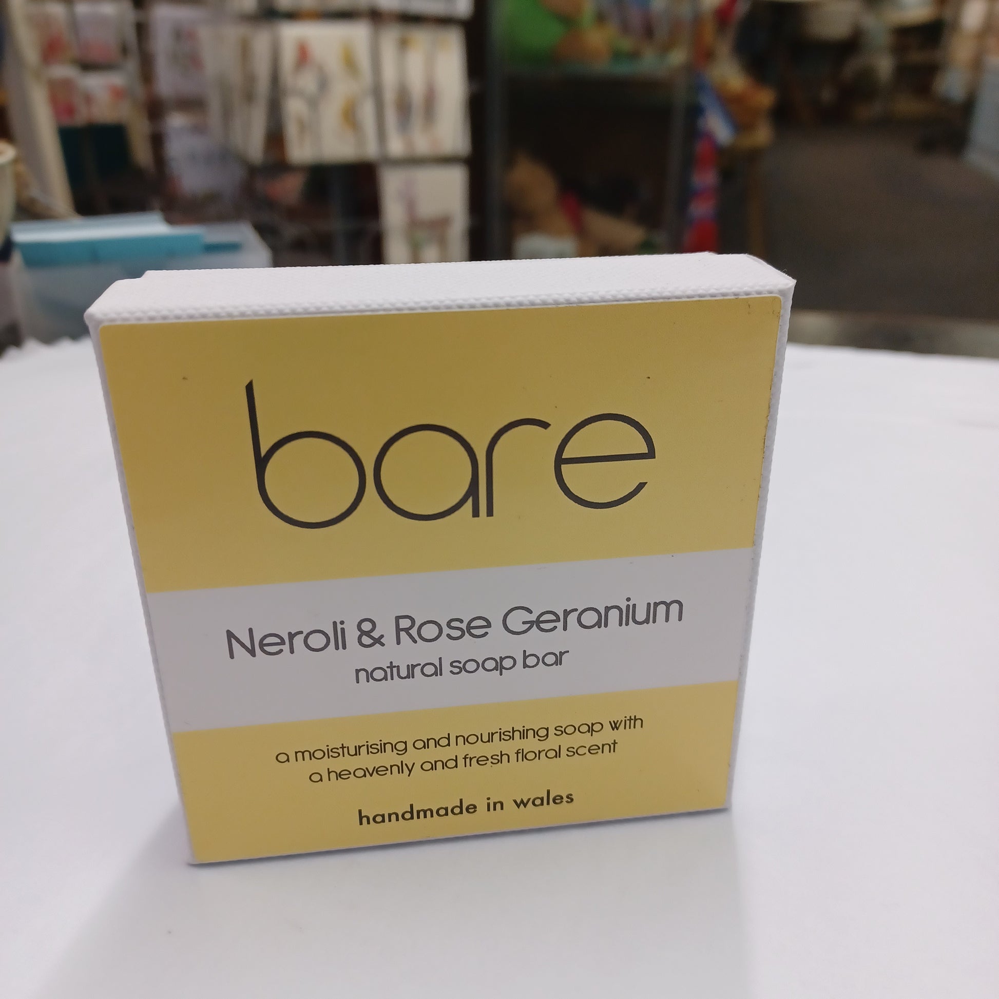 Bare Neroli & Rose Geranium soap bar packaging on a shelf.